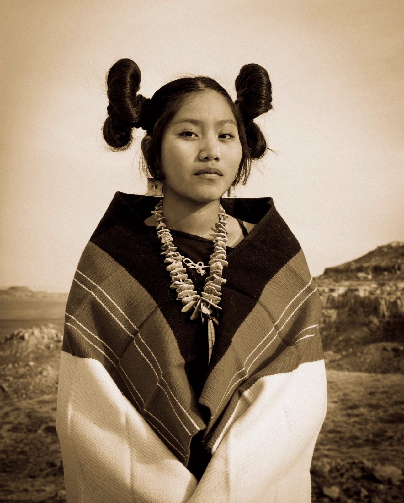 Portrait of a young Hopi woman in a striped blanket and turquoise