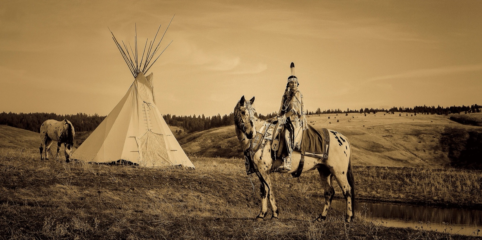 A horseback rider beside a tipi on the open plains
