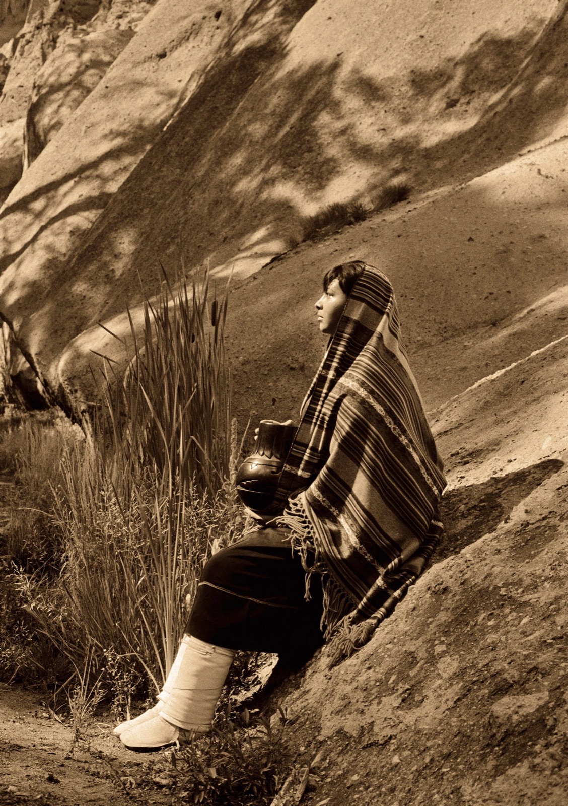A girl seated on a rock in the high country